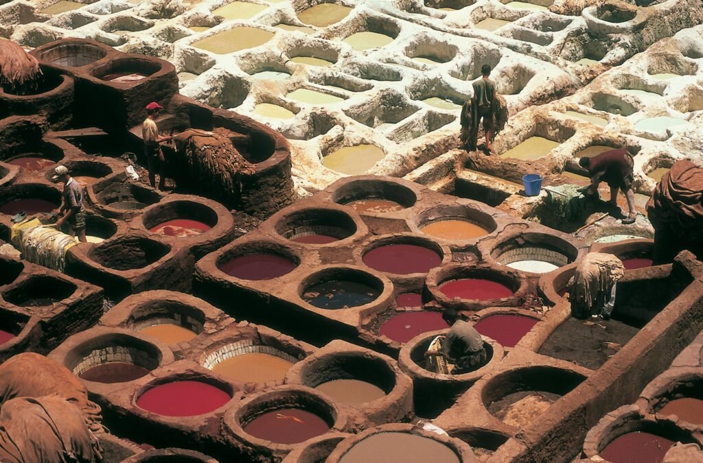 Overhead view of traditional tannery pits in Fez, Morocco with workers busy at work.