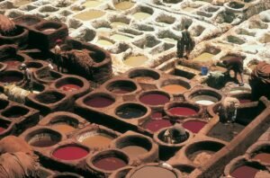 Overhead view of traditional tannery pits in Fez, Morocco with workers busy at work.
