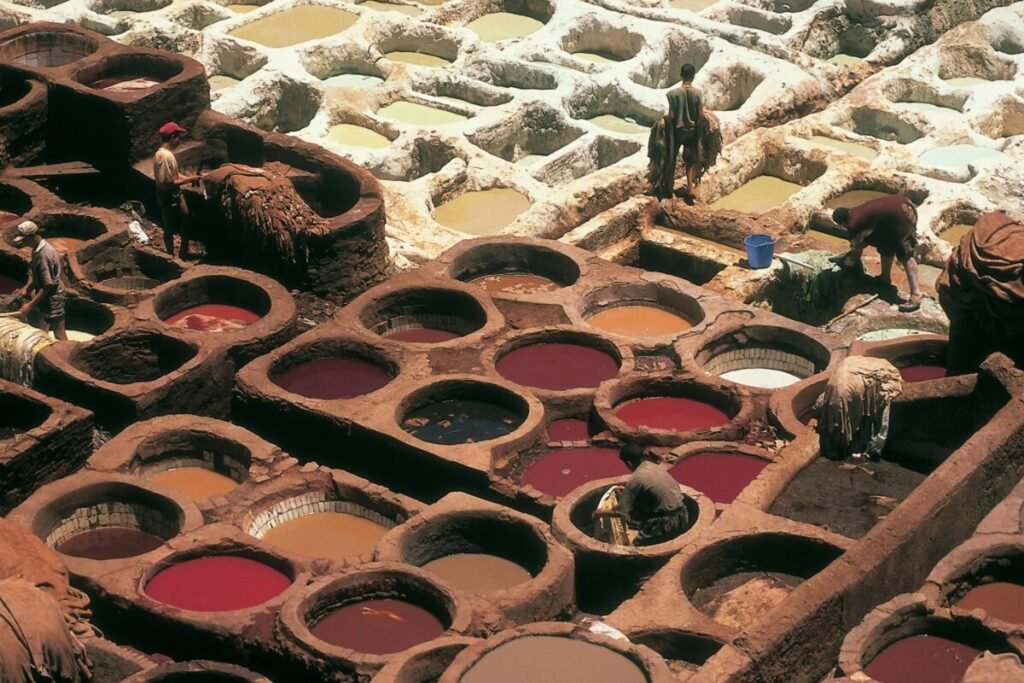 Overhead view of traditional tannery pits in Fez, Morocco with workers busy at work.