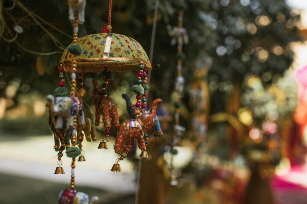 Vibrant Indian-style hanging decorations with elephants and camels in an outdoor setting.
