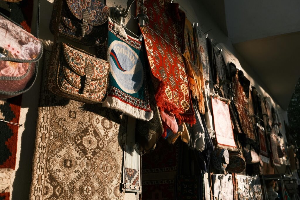 A vibrant array of traditional tapestries and bags hanging under warm lighting, creating a rich cultural scene.