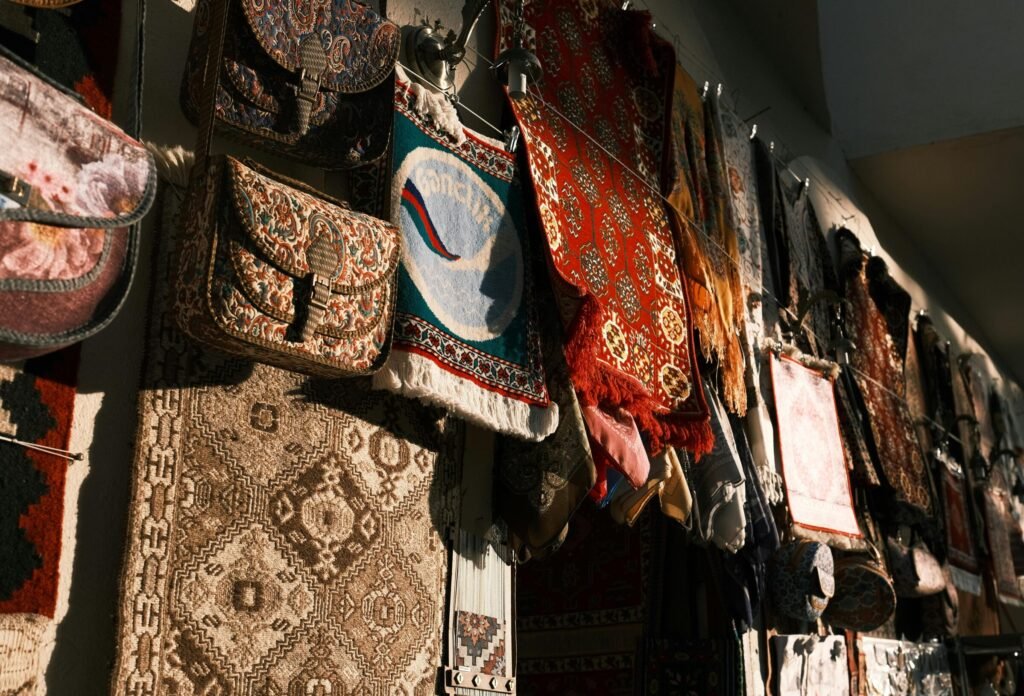 A vibrant array of traditional tapestries and bags hanging under warm lighting, creating a rich cultural scene.