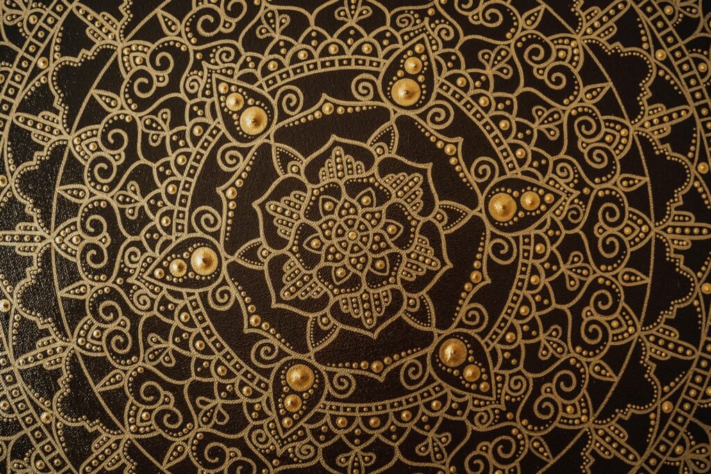 Close-up of an intricate gold mandala pattern on a dark canvas, showcasing detailed artistry.
