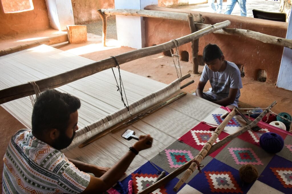 Artisan and child weaving a colorful carpet on a handloom in Jodhpur, Rajasthan.